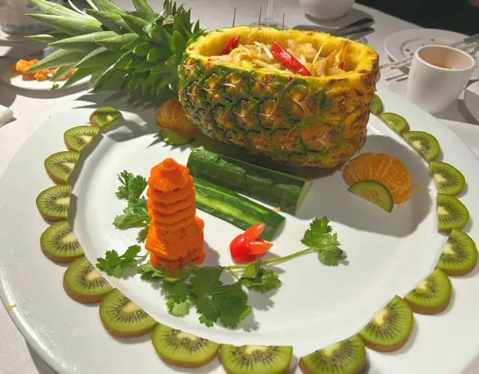 Pineapple boat seafood presentation with kiwi ring